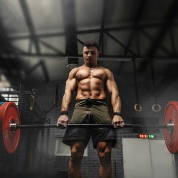 shirtless man weightlifting a heavy barbell