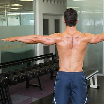 shirtless man showing his back while both arms are raised