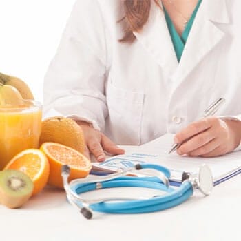 table view of a nutritionist writing with fruits on the side