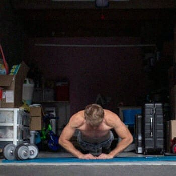 A man doing a diamond push-ups in his garage