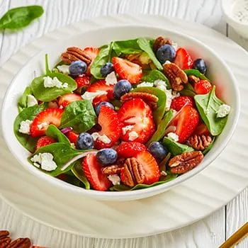 berries, nuts and green leaves in a bowl
