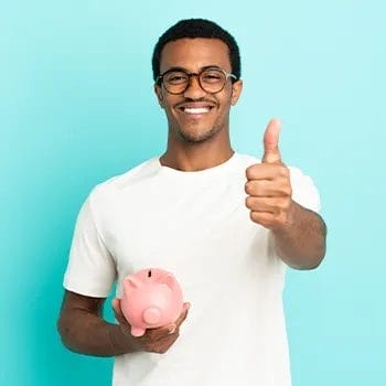 man holding up a piggy bank and a thumbs up
