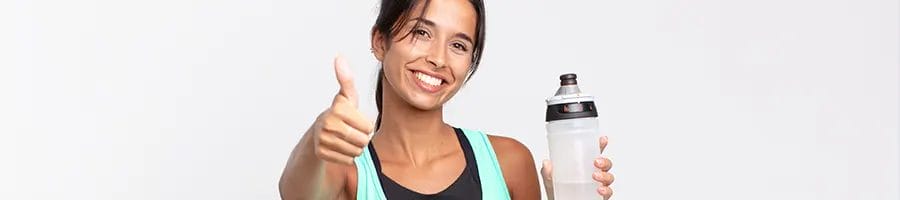 woman holding up a tumbler and a thumbs up
