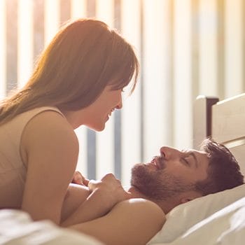 man and woman on top of each other in bed