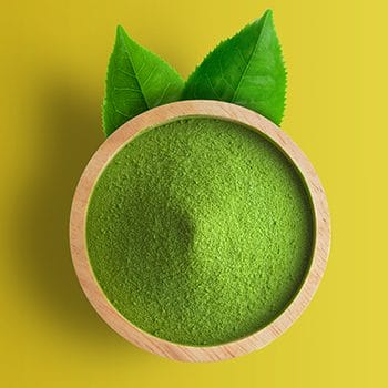 wooden bowl filled with green tea powder