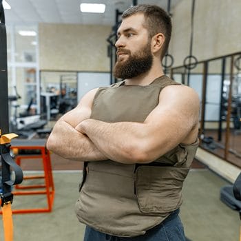 man with his arms crossed while wearing a weighted vest