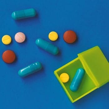 A bunch of pills and tablets on a blue table