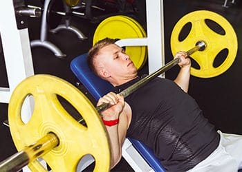 man in a bench press machine at a gym