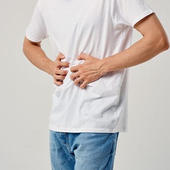 man placing his hands on his stomach while in pain