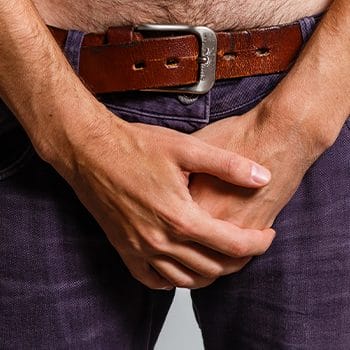 close up image of a man with his hands on his pants