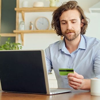man using a pc and his credit card