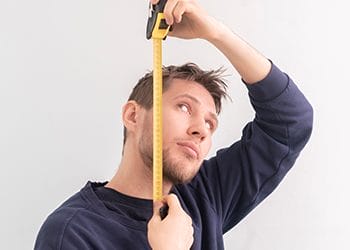 man using tape measure for his height