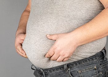 man holding his belly fat