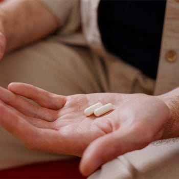 hand with two white pills