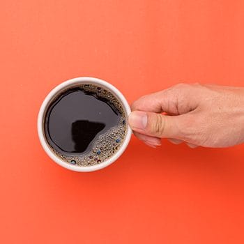 hand view of a man holding a cup of coffee