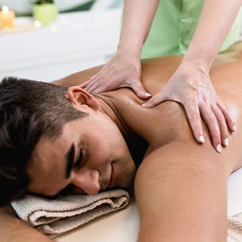 shirtless man getting massaged