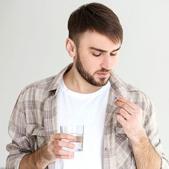 man drinking meds
