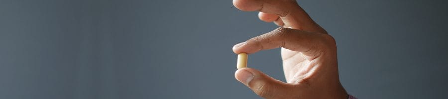 hand view of a person holding a pill