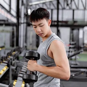 asian man working out with a dumbbell