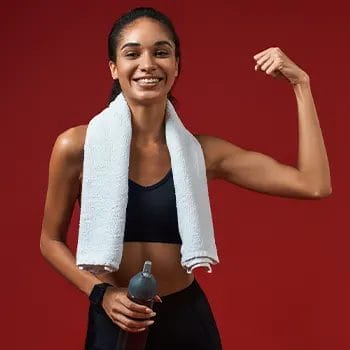 woman showing off her arm muscles in gym clothes
