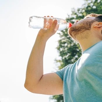 man chugging a bottle of water