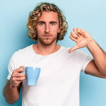 man holding up a mug and his thumbs down