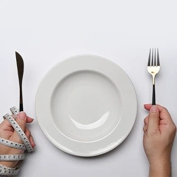 empty plate with one hand covered in tape measure
