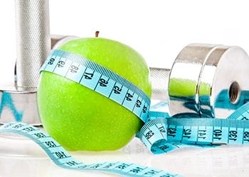 dumbbells, tape measure, and apple