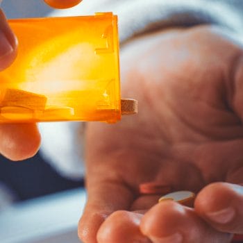 Someone pouring out pills onto a hand