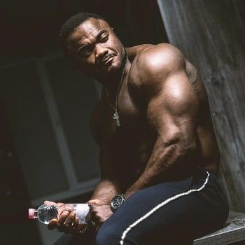 A muscular man sitting in the dark