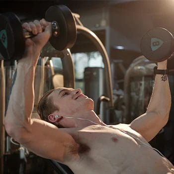 Performing an incline dumbbell press in the gym