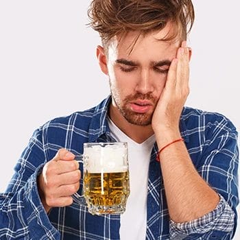 A person with a mild headache while drinking beer
