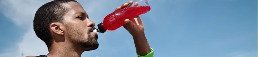 A person drinking energy drink outdoors