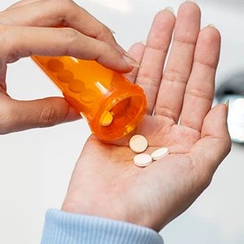 Pouring diet pills on hand