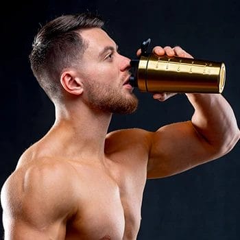 A muscular person drinking a supplement drink