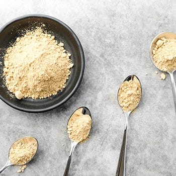 Different types of protein powders on a spoon and bowl