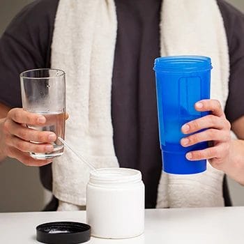 A person holding a glass of water and a tumbler