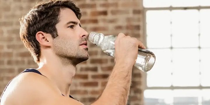 A man drinking water from a water bottle