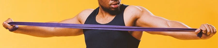 A buff person stretching a resistance band