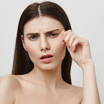 A woman looking at herself and pinching her skin