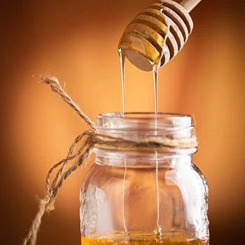Pouring honey in a container