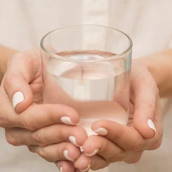 Close up image holding a glass of water