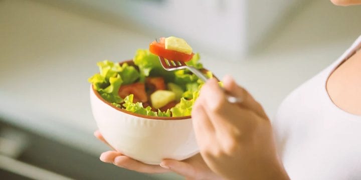 A person eating a salad bowl