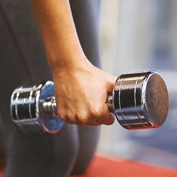 Close up shot of someone's hand lifting weights