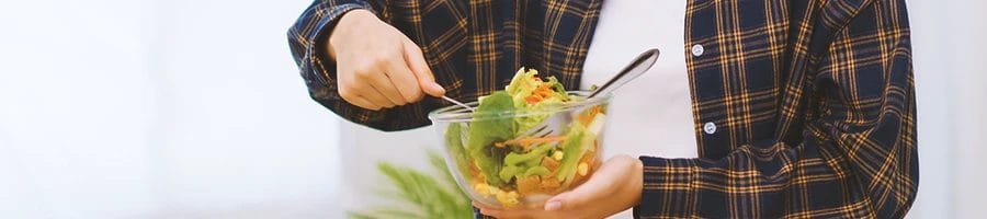 A person holding a salad bowl