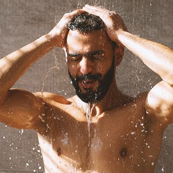 A buff male taking a shower