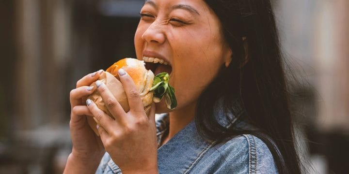 A person eating a fatty hamburger