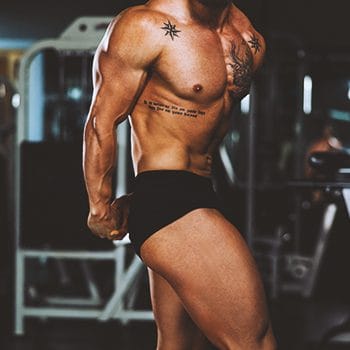A muscular male in the gym posing for the camera