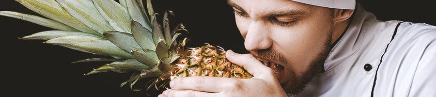 A chef eating a pineapple