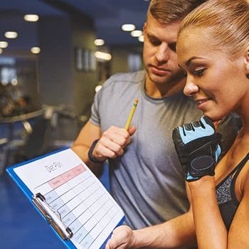 A gym trainer with a person planning a diet